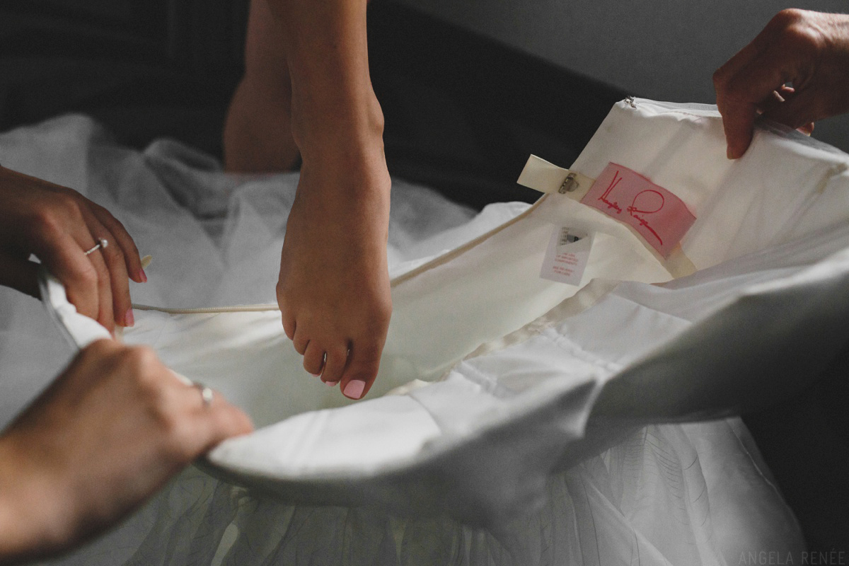 bride stepping into wedding dress