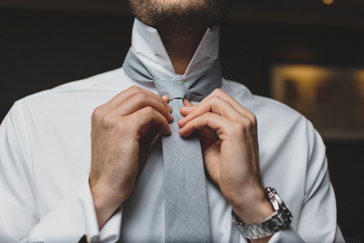 groom putting on tie