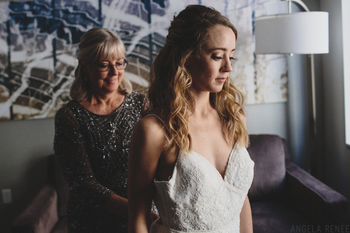 bride putting on wedding dress