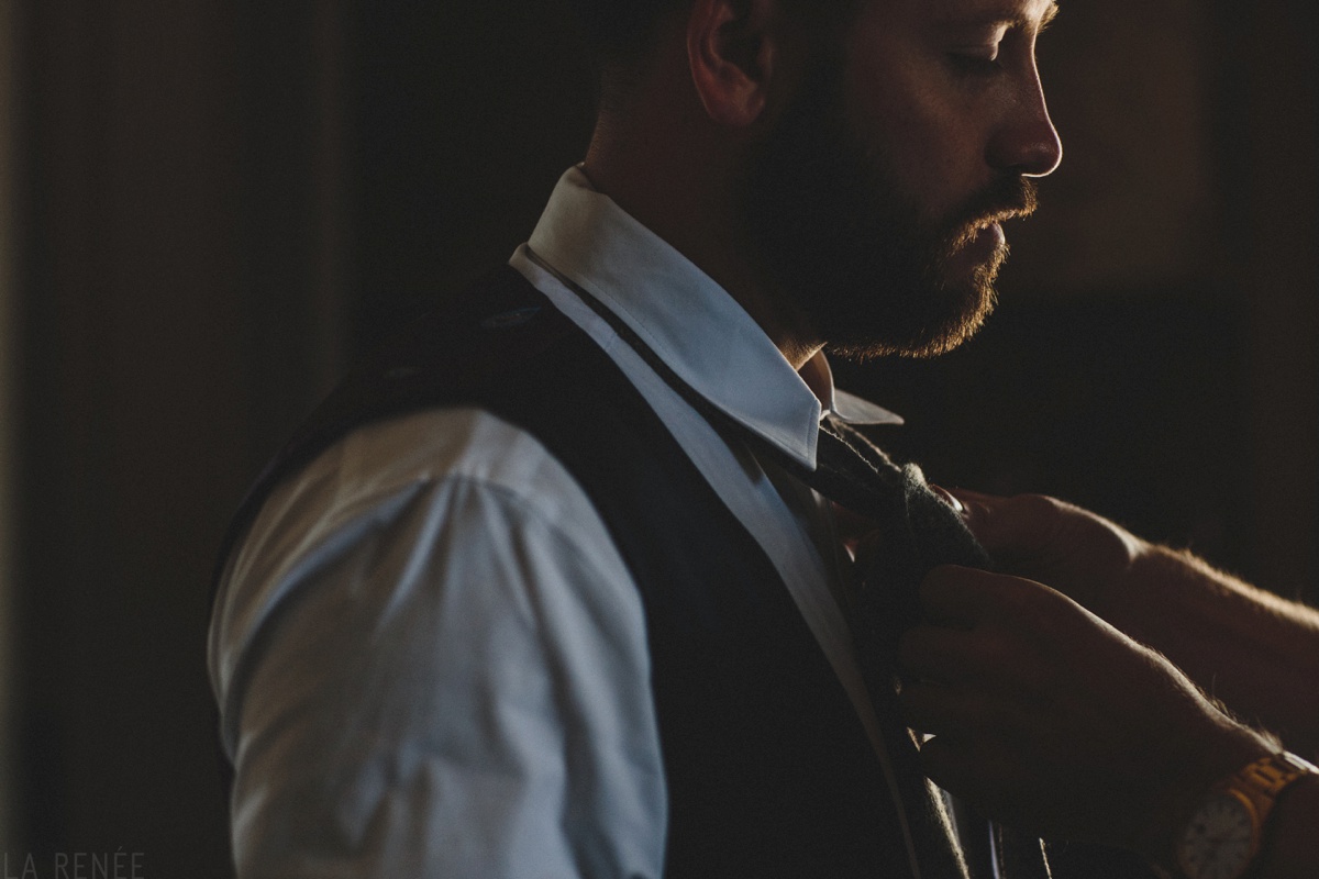 groom putting on tie