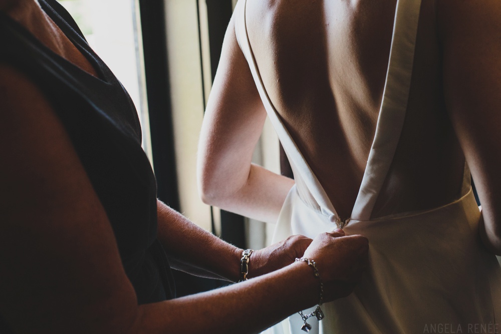 mother-of-bride-putting-on-dress